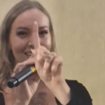 Dando palestra em universidade, com vestido curto e dancinha, palestrante choca ao cantar “Ensinando com o c*”